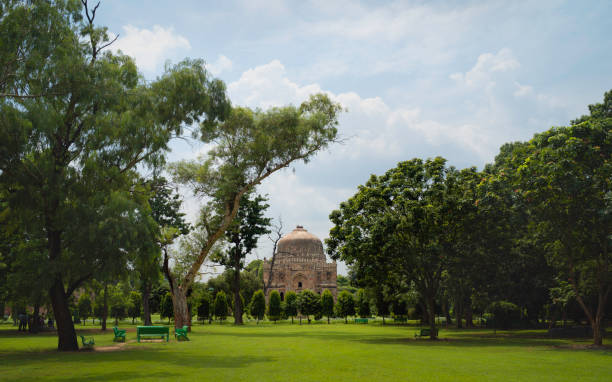 Bara Gumbad or big dome in Lodi Gardens, Delhi, India. Bara Gumbad, or big dome, on a summer morning surrounded by trees and grass lawns under blue cloudy sky in Lodi gardens in Delhi, Uttar Pradesh, India. lodi gardens stock pictures, royalty-free photos & images