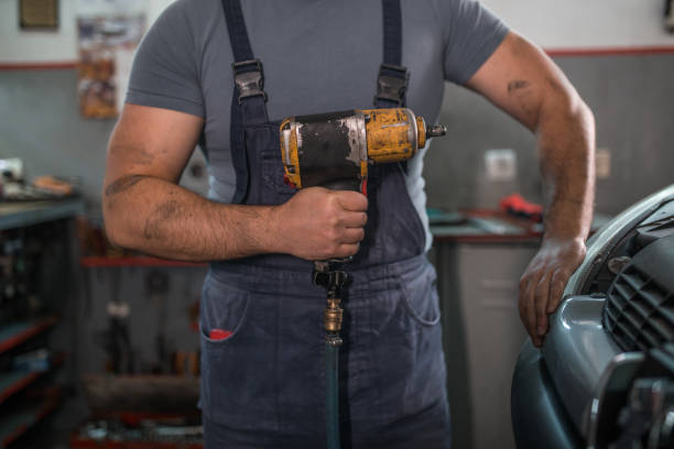 istock Car mechanic holding machine tool for changing tires 1325408896