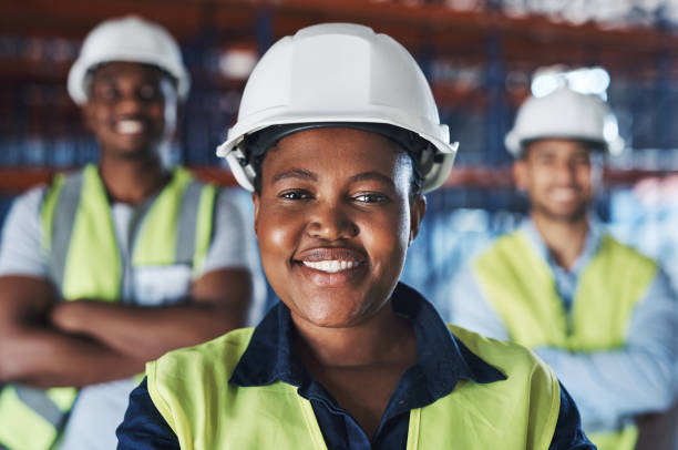 schuss einer gruppe von auftragnehmern, die gemeinsam im lager stehen - construction worker hardhat safety manual worker stock-fotos und bilder