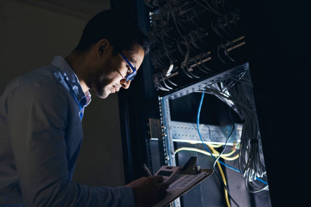 istock Shot of a handsome young technician standing alone and looking at the mainframe 1325412425
