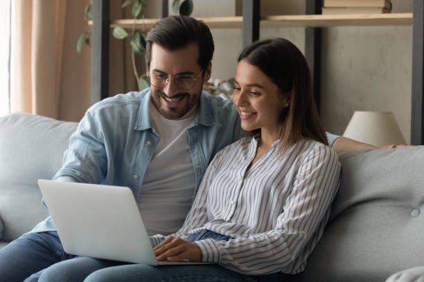 istock Relaxed happy young family couple using computer at home. 1325412568