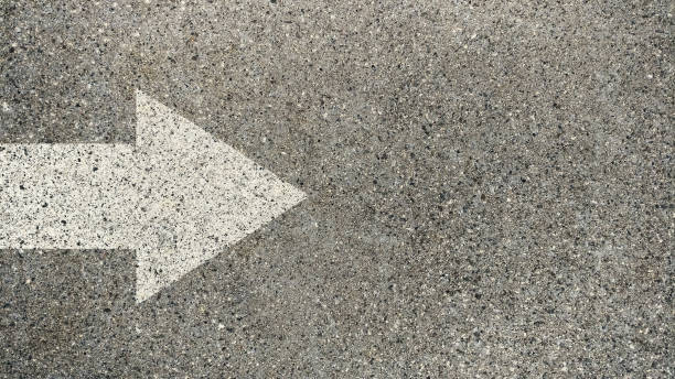 istock White arrow direction on asphalt street road. 1325413770