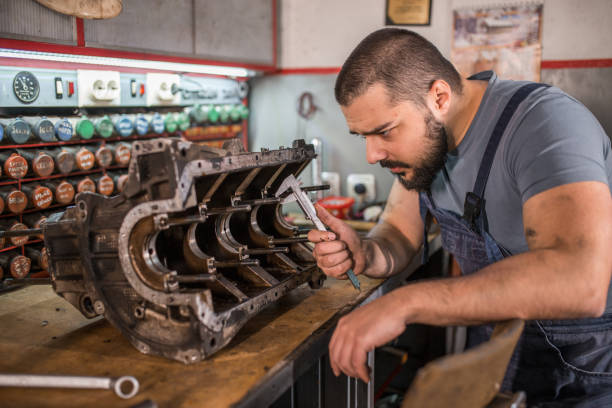 istock Car mechanic using manual tools to repair engine in auto repair shop 1325415409