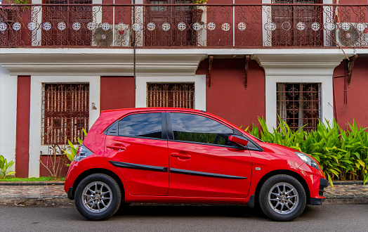 Panjim, Goa, India - January 4 2021: Red car parked near building at the street