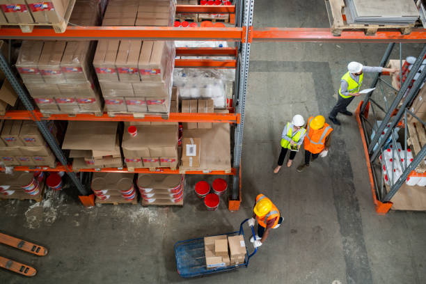 istock One of warehouse workers pushing cart with boxes 1325417157