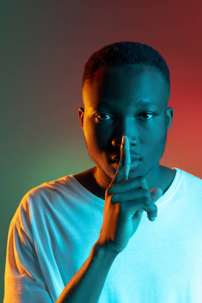 istock African young man's portrait on bright studio background in neon light. Handsome male model in casual style. 1325418402