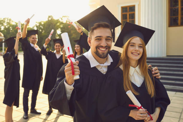 istock Happy graduates with degree certificates looking at camera 1325419536
