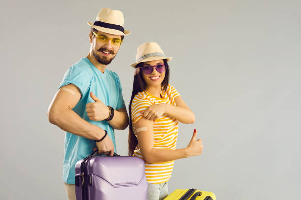 istock Couple traveler show patch on arms to camera stand with bag on studio copy space 1325420583
