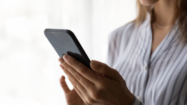 istock Close up unrecognizable young woman holding cellphone. 1325420932