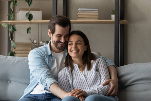 istock Smiling bonding young couple relaxing on cozy sofa. 1325420971