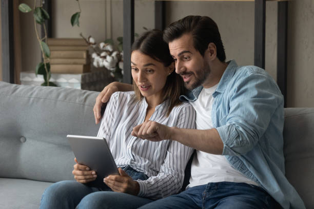 istock Surprised young happy couple looking at digital computer tablet. 1325420976