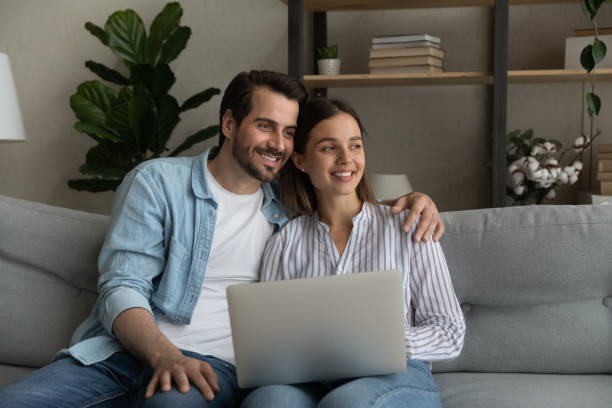 istock Happy dreamy bonding young family couple using computer. 1325420978