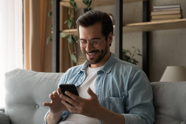 istock Happy young man in eyeglasses using smartphone. 1325420988