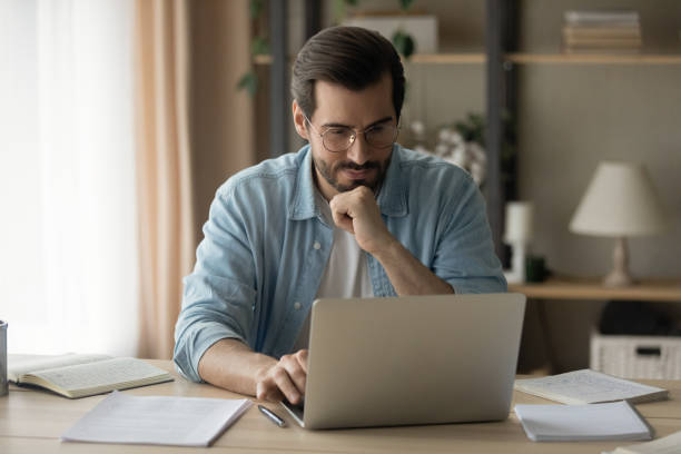 istock Concentrated happy young business man working on computer at home. 1325420993