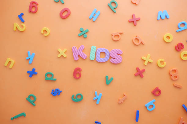 istock colorful plastic letters on orange background, Top view 1325421102