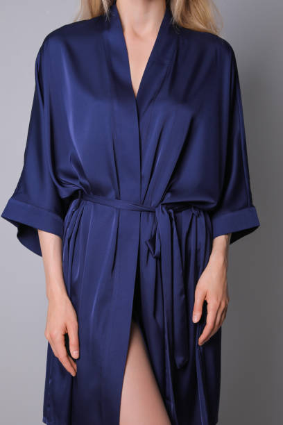 istock Woman in beautiful dark blue silk robe on grey background, closeup 1325422121