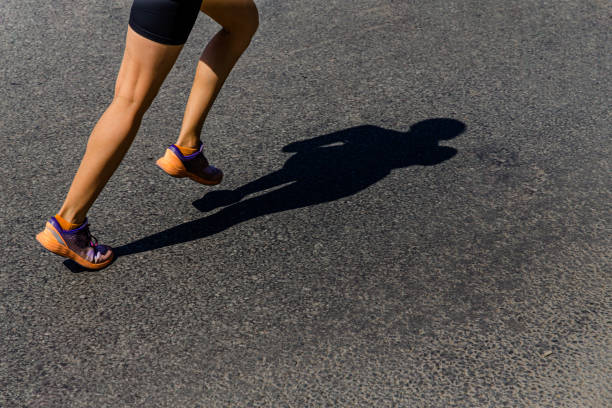 istock girl runner run shadow on dark road 1325422598
