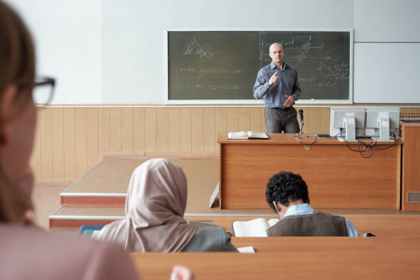 istock Mature man standing by blackboard during explanation of subject 1325422802