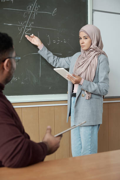 istock Student in hijab pointing at blackboard 1325422835
