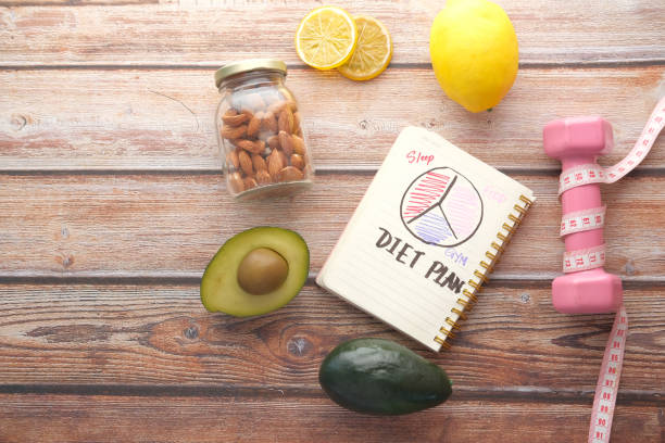 istock Diet plan with apple and dumbbell on wooden background 1325423783