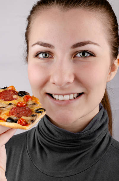 istock Happy smiling caucasian female young model holds pizza slice 1325426938