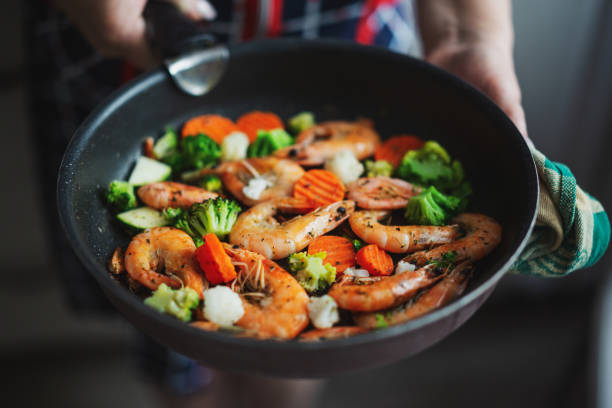 istock Cooking vegetables and shrimps on pan 1325428460