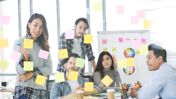 istock Diversity multi ethnic group brainstorming teams with business partner meeting and share ideas in conference room. Creative design colleague talking strategy plan use sticky notes post, present ideas 1325428500