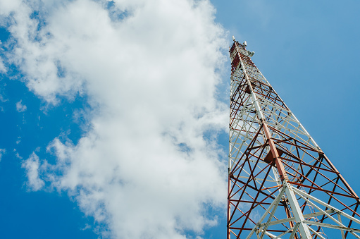 metal tower for mobile radio communication on background of blue sky