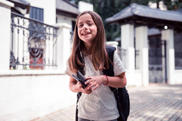 child holding a mobile phone - homework teenager mobile phone school imagens e fotografias de stock