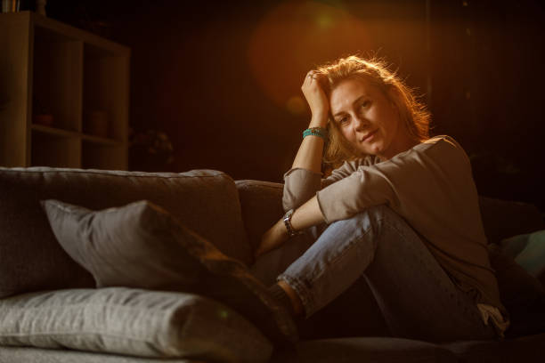 istock Copy space shot of woman smiling at camera while relaxing on the sofa 1325434698