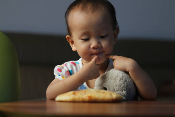 istock a Asian girl eating clay oven rolls at home. 1325437101