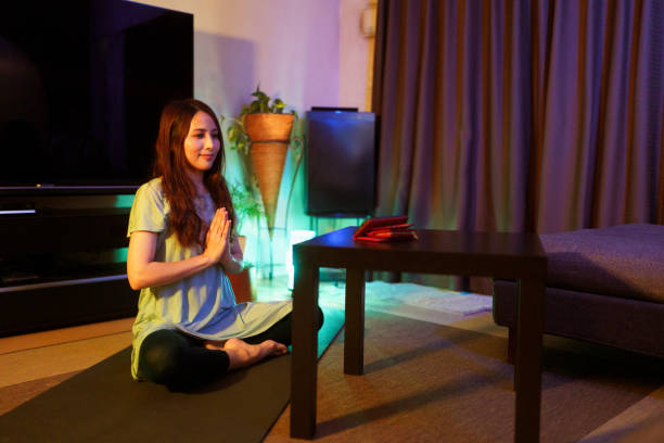 istock Woman practicing yoga while watching online yoga tutorials on smart phone at home at night 1325437506