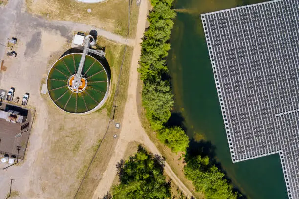 Aerial top view solar power station float the pond near recirculation sedimentation tank, water treatment plant