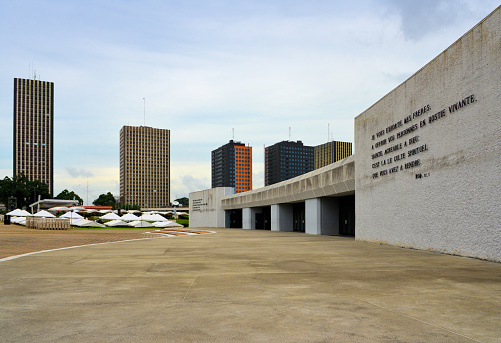 Abidjan, Ivory Coast / Côte d'Ivoire: towers of the government campus (Cité Administrative ) and Saint Paul's Roman Catholic cathedral, Archdiocese of Abidjan - architect Aldo Spirito - Plateau district - Bible quotes on the facade, Roman 12.1 \