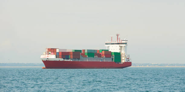 istock Huge container tanker ship carrying truck size colourful containers in deep blue open ocean sea 1325449336