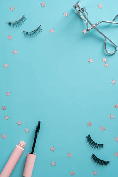 istock Mascara with false eyelashes and tools on blue background. Flat lay, top view. 1325452411