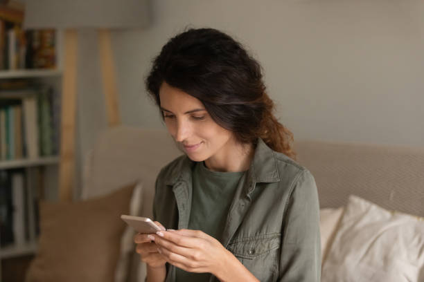 istock Close up attractive woman holding smartphone, looking at screen 1325452772