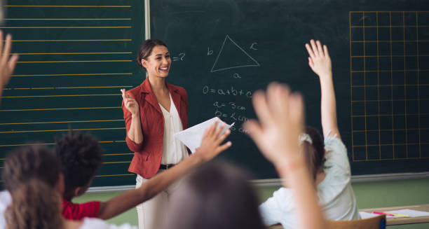 maestra frente a su clase, haciendo preguntas. - back to school young women cheerful happiness fotografías e imágenes de stock