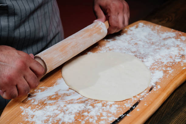 istock hands roll the dough into a thin layer. Cooking pizza, noodles or pitta at home 1325455548