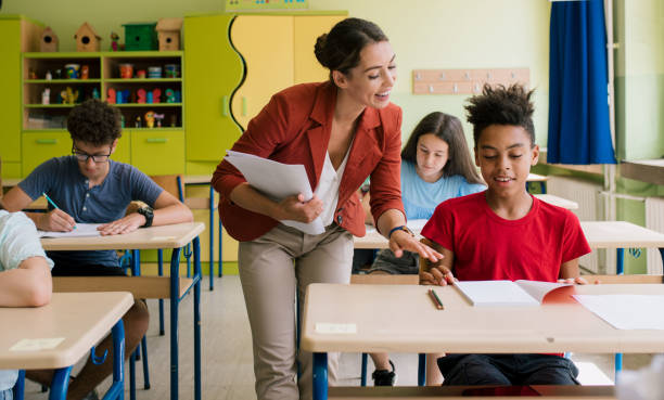 istock Teacher helping pupil. 1325458660