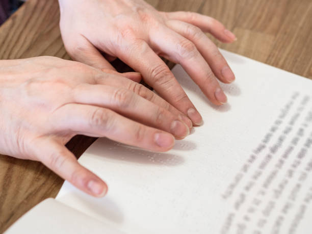 istock female fingers read book with braille and text 1325459355