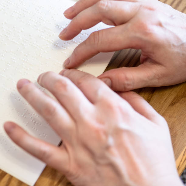 istock woman read book with braille by fingertips closeup 1325459388
