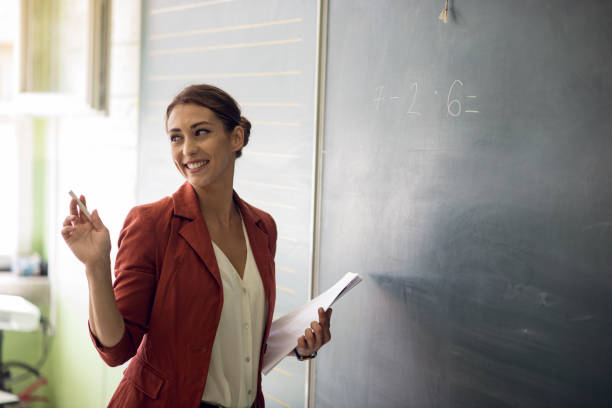 учитель письменной форме на доске в классе. - professor teacher female blackboard стоковые фото и изображения