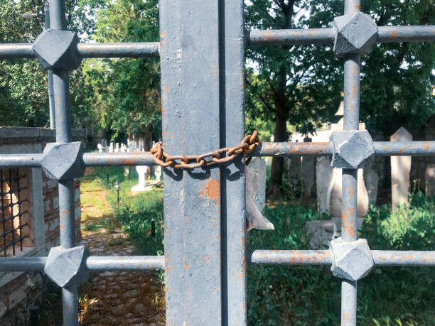 istock padlocked gray iron gate door with rusty chains before a Muslim Turkish cemetary safety and security concept 1325461701