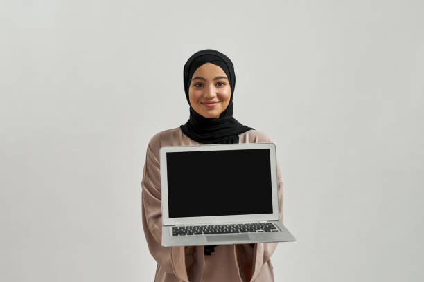 istock Young arabian woman demonstrating laptop screen 1325463861