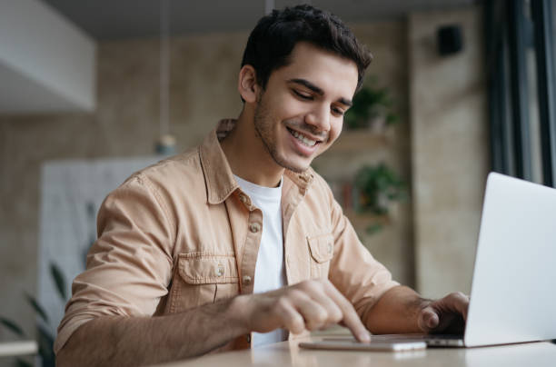 étudiant asiatique étudiant, apprenant la langue. homme d’affaires attrayant travaillant projet de démarrage en fonction. portrait d’un rédacteur indépendant indien à succès utilisant un ordinateur portable, tapant sur le clavier - technology typing male beauty asian and indian ethnicities photos et images de collection