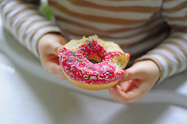 istock pink doughnut in the hands of a child 1325466101