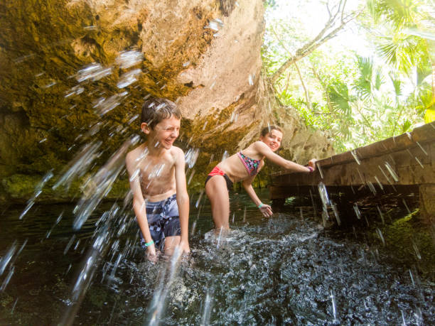 crianças nadando no cenote em cancun - fun simplicity children only color image - fotografias e filmes do acervo