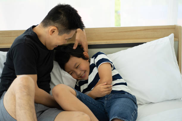 istock Asian father playing with son at home 1325467473