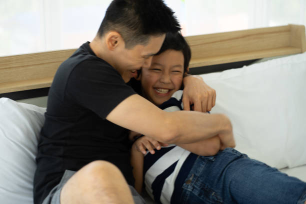 istock Asian father playing with son at home 1325468047